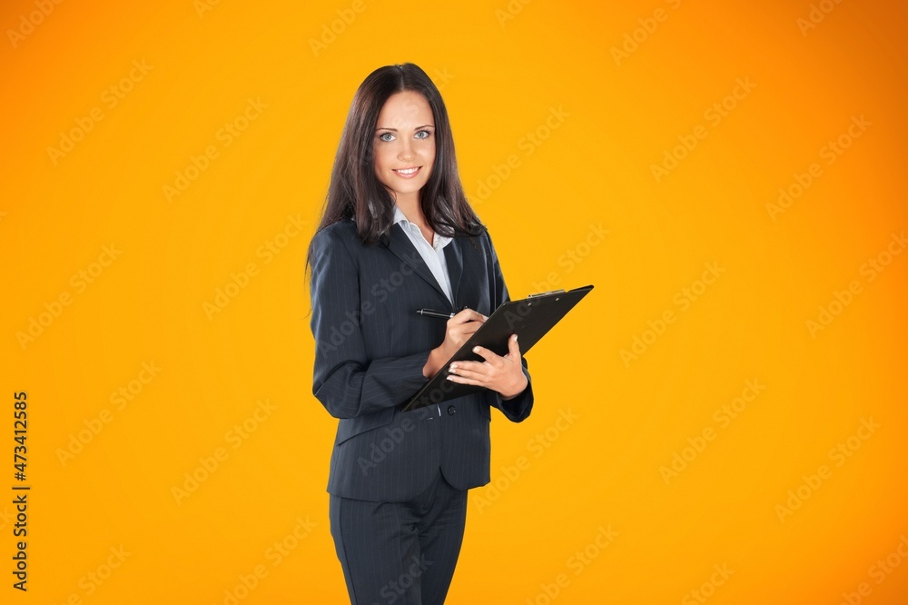 Smiling woman student with school books in hands on the background.