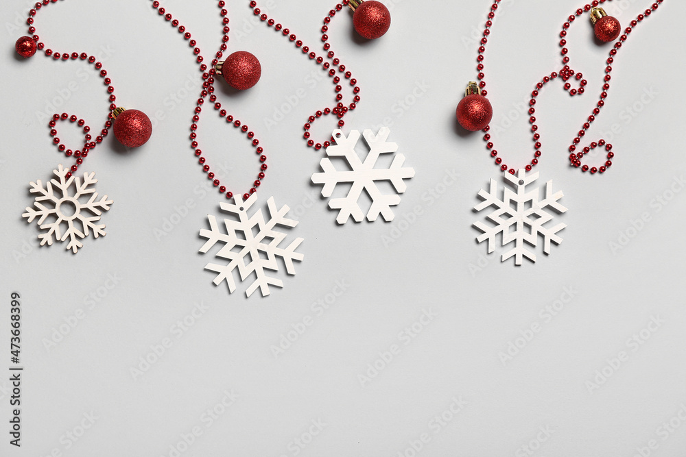 Beautiful snowflakes, Christmas balls and beads on light background