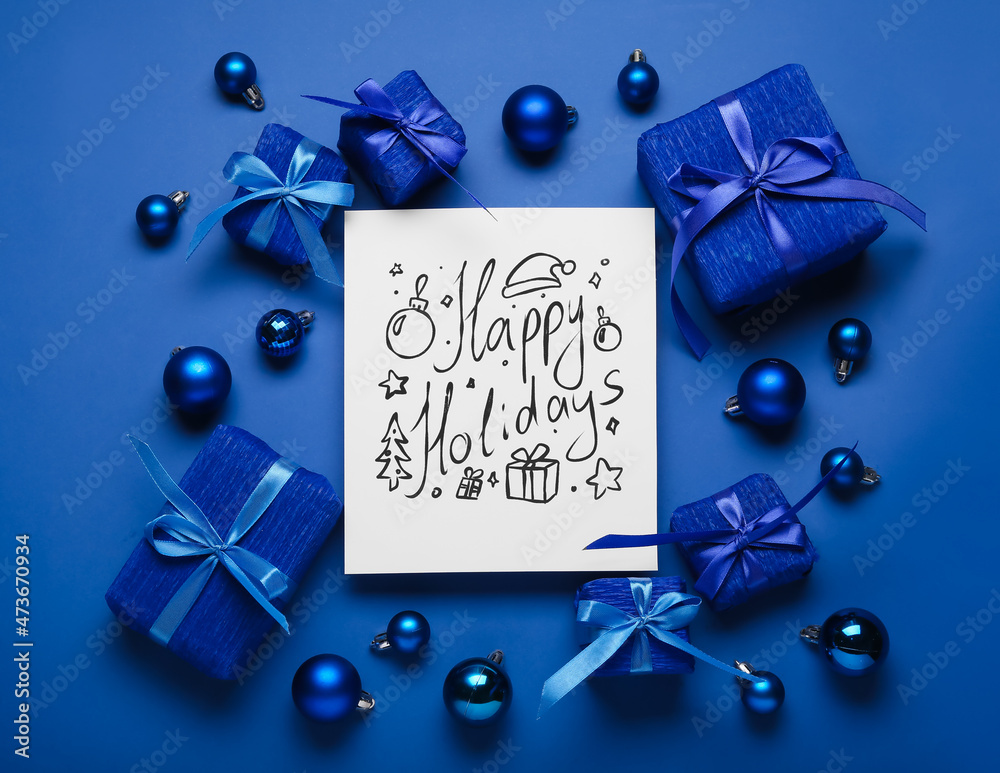 Greeting card with text HAPPY HOLIDAYS, gift boxes and Christmas balls on blue background