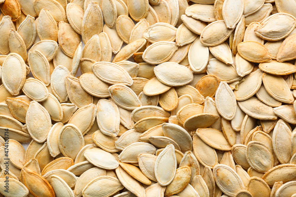 Natural pumpkin seeds as background, closeup