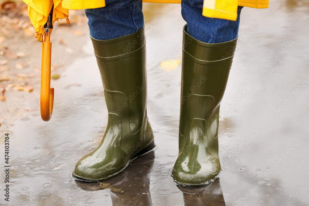 Man wearing gumboots in park on autumn day, closeup