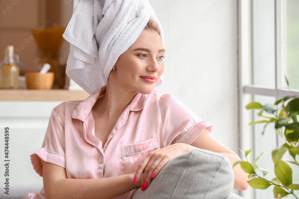 Pretty young woman sitting on sofa after shower