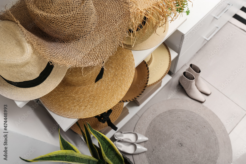 Different straw hats on shelves in wardrobe, closeup