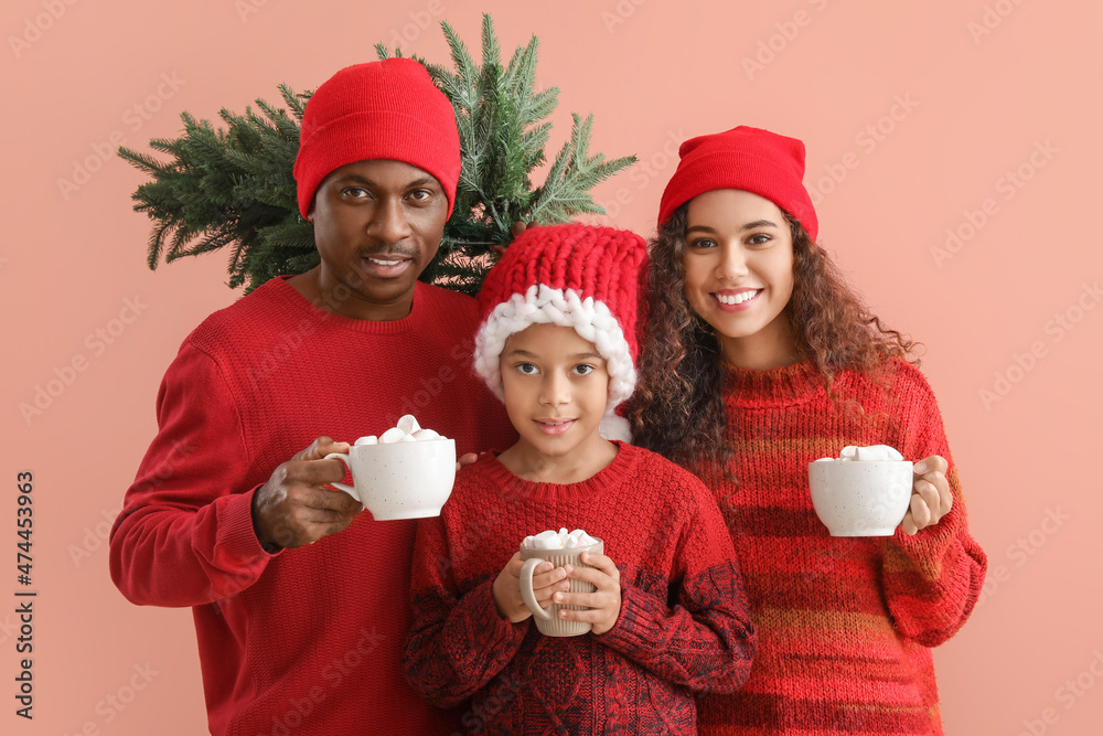 African-American family in winter clothes, with tasty hot chocolate and Christmas tree on color back