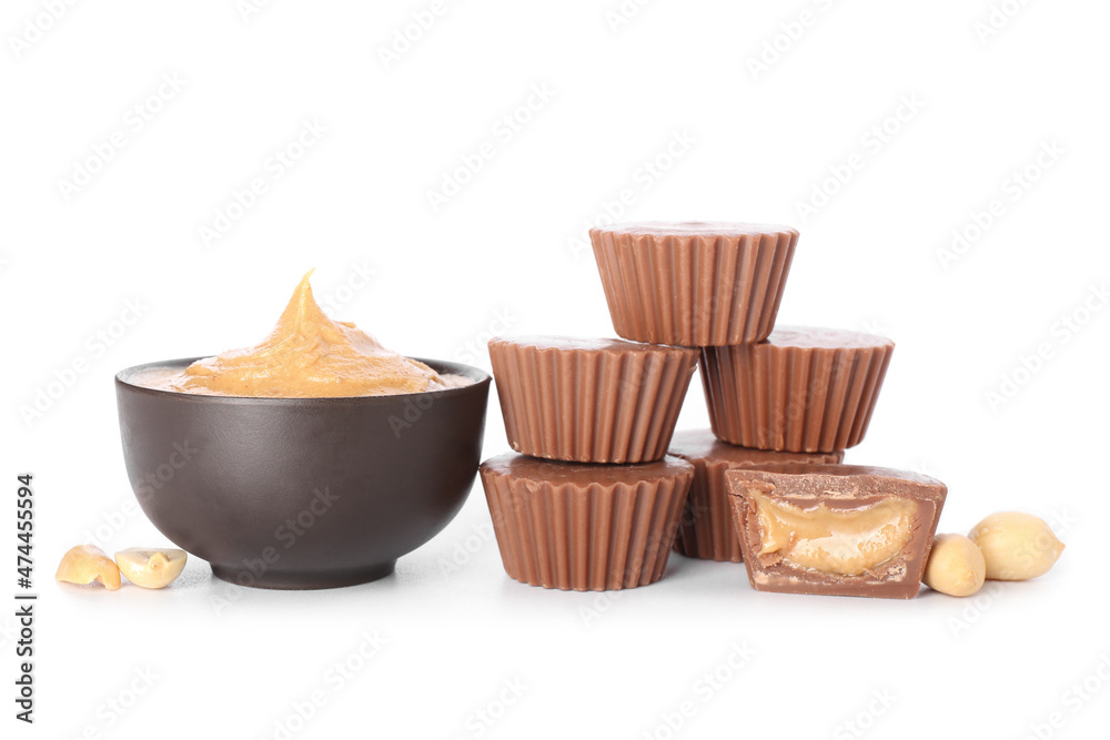 Tasty peanut butter cups on white background