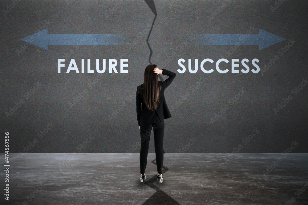 Back view of young european businesswoman with failure and success arrows sketch on concrete backgro