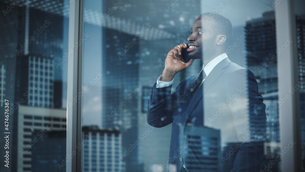 Portrait of Successful African-American Businessman Standing in Office, Making Phone Call to Close t