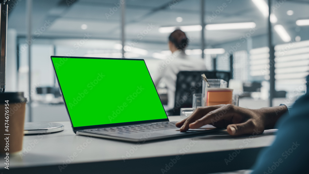 Successful Black Businessman Sitting at Desk Working on Green Screen Chroma Key Laptop Computer in B