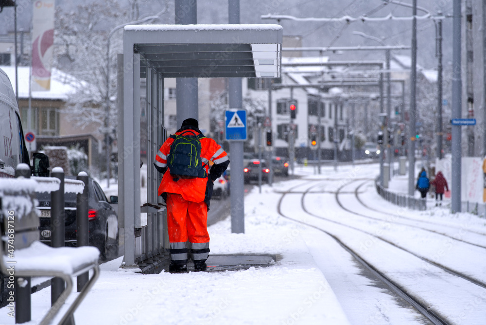 Worker at tram station at City of Zürich on a snowy winter day. Photo taken December 10th, 2021, Zur