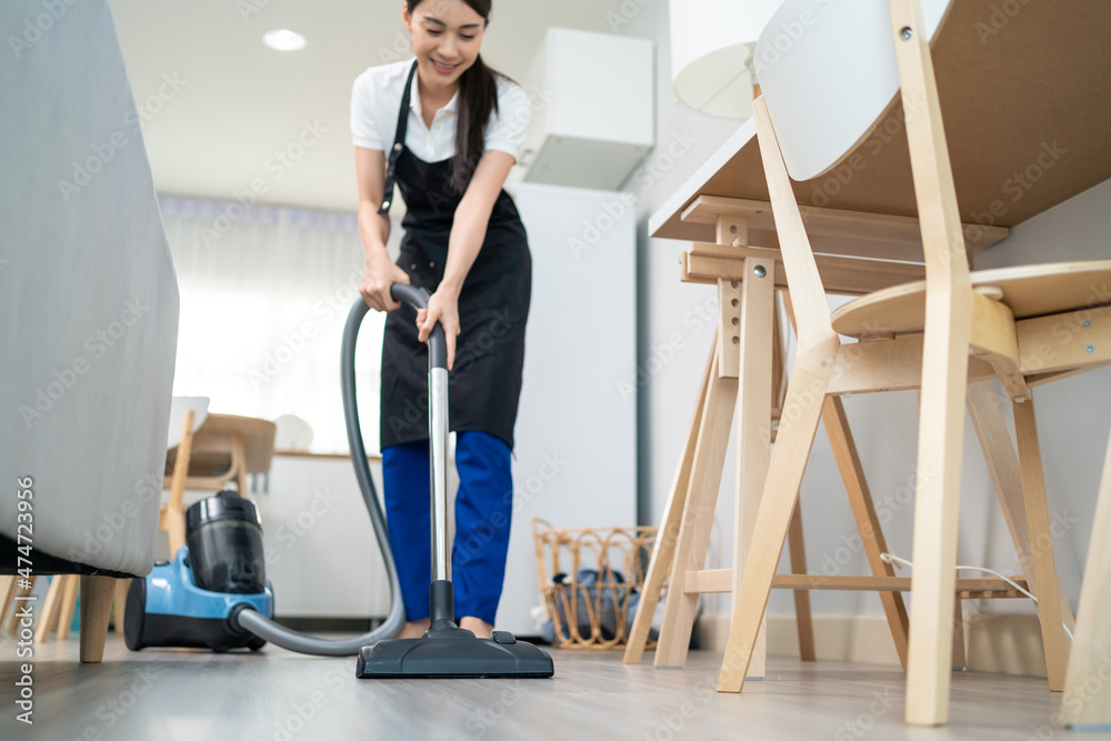 亚洲清洁服务女工在家中客厅清洁。