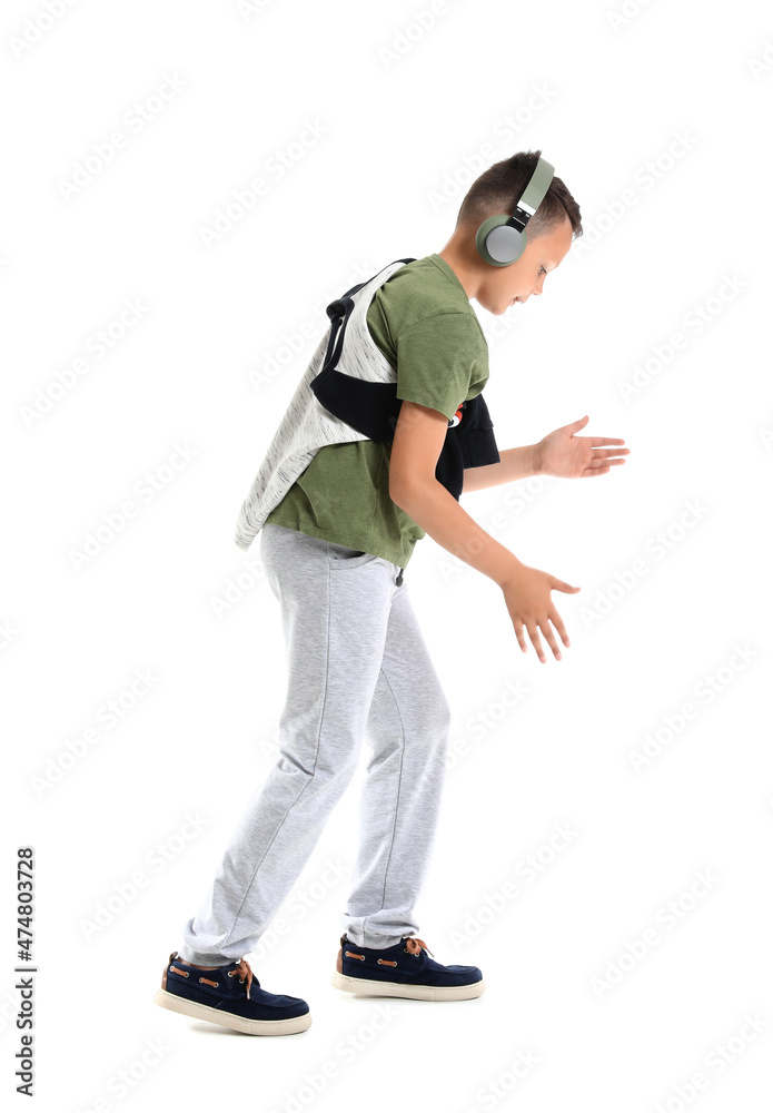 Dancing little boy listening to music, isolated on white