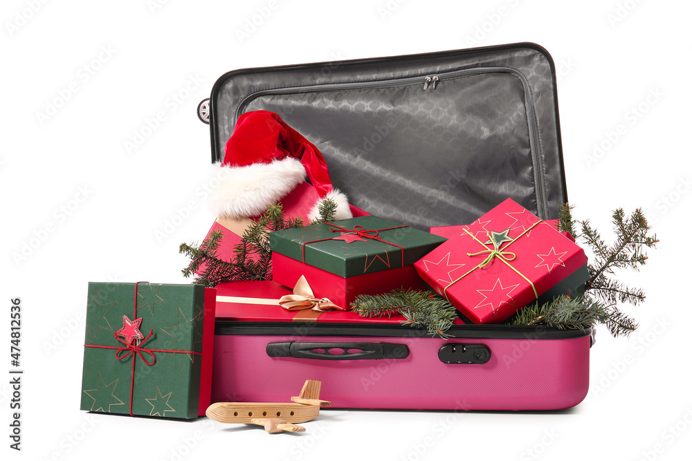 Suitcase with gift boxes, fir branches and Santa hat on white background. Christmas vacation concept