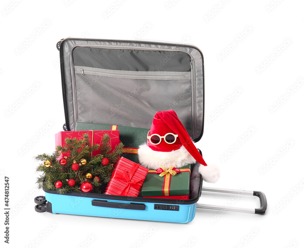 Suitcase with gift boxes, Santa hat and decorated fir branch on white background. Christmas vacation