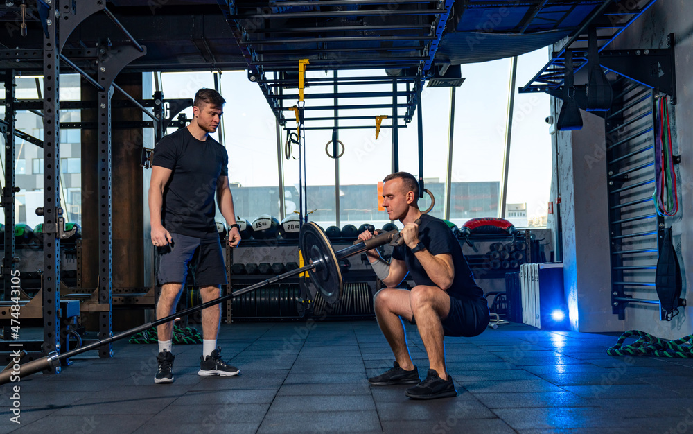 Two strong men training in the gym. Lifestyle athletic male working out hard.