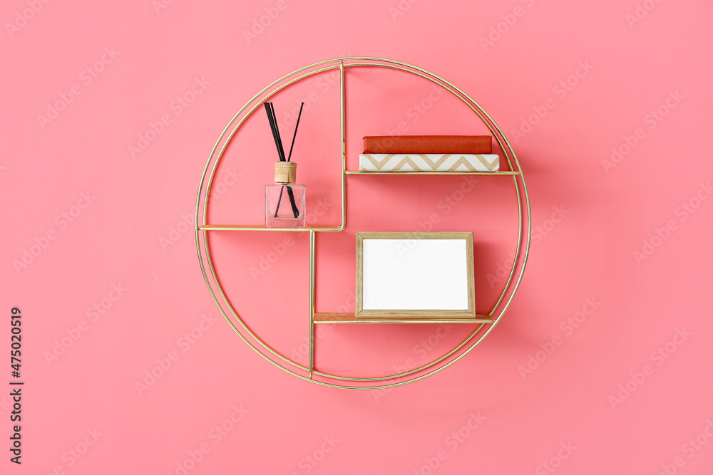 Modern shelf with books and decor on color wall