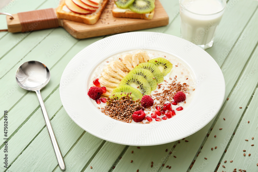 Tasty yoghurt with fruits and flax seeds in bowl on table