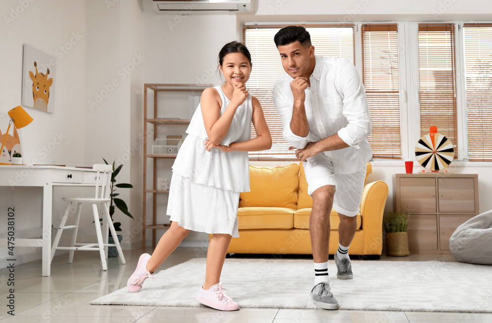 Man and his little daughter dancing at home