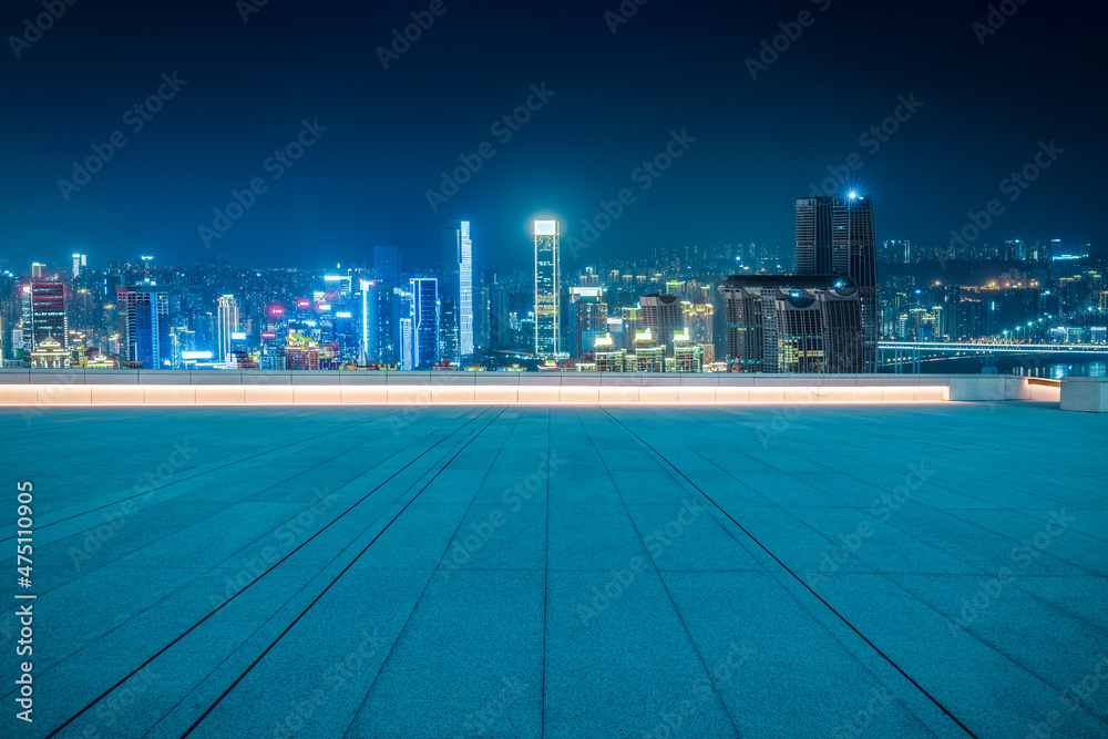 Panoramic skyline and modern commercial buildings with empty square at night