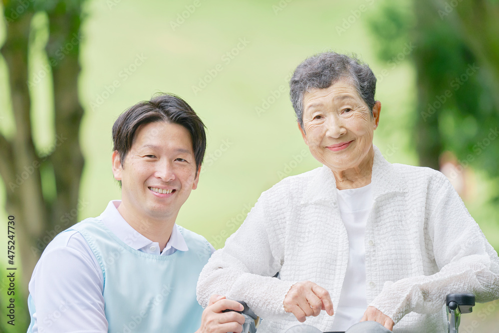 介護士と車椅子に乗る高齢者　屋外　ポートレート