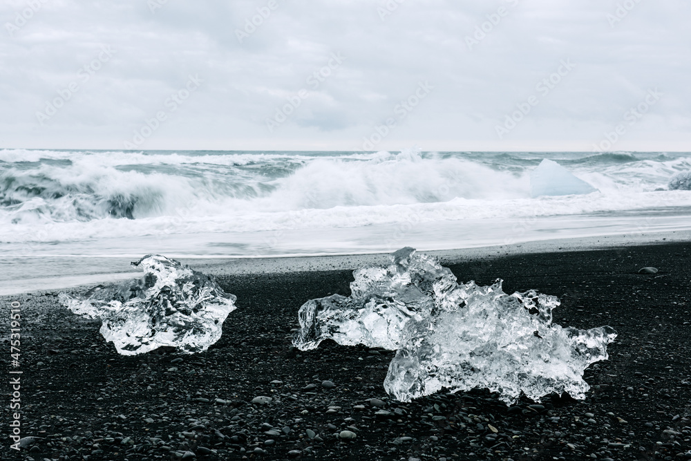 冰岛Jokulsarlon泻湖附近黑钻石海滩上的冰山碎片。大西洋的海浪和clo