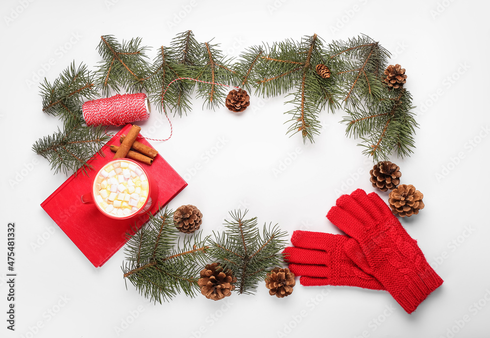 Frame made of fir branches, cones, cup of cacao and gloves on white background