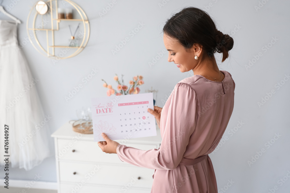 Female wedding planner with Save the Date Announcement in office