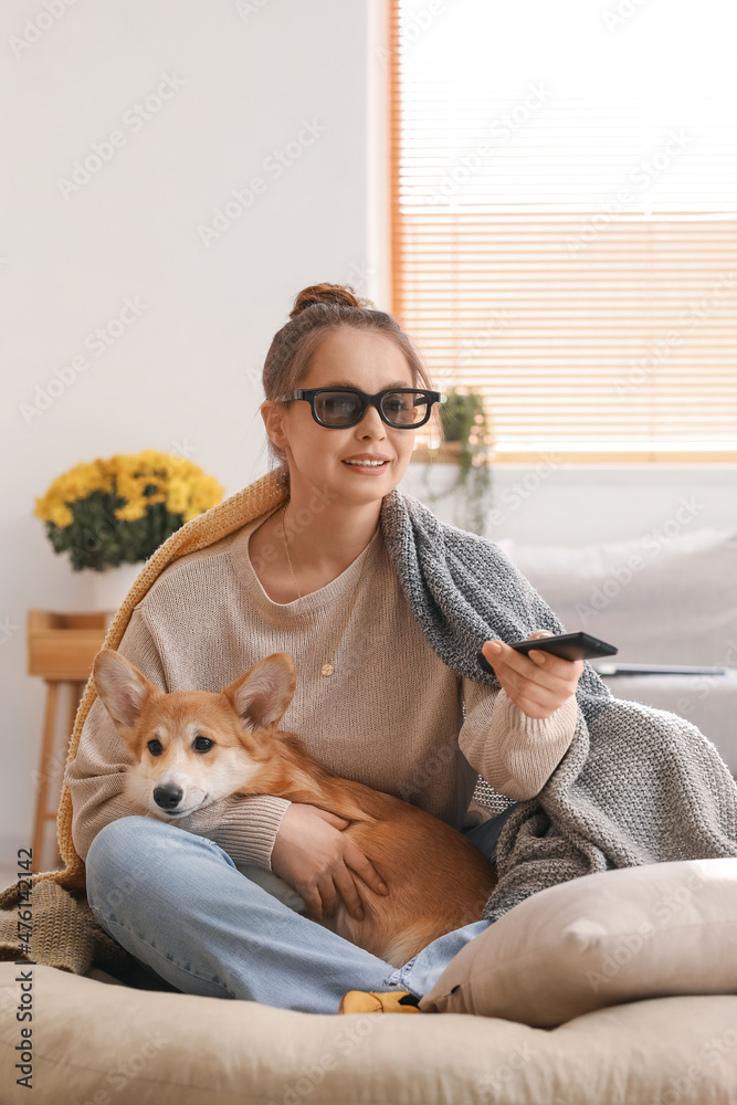 戴着3d眼镜的年轻女子和可爱的柯基犬在家看电视