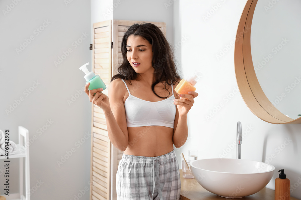 Morning of beautiful young woman with liquid soap in bathroom