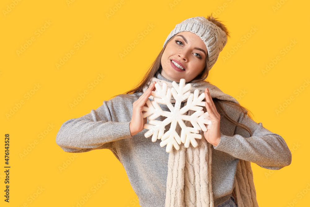 美丽的年轻女子，穿着温暖的冬装，背景是雪花