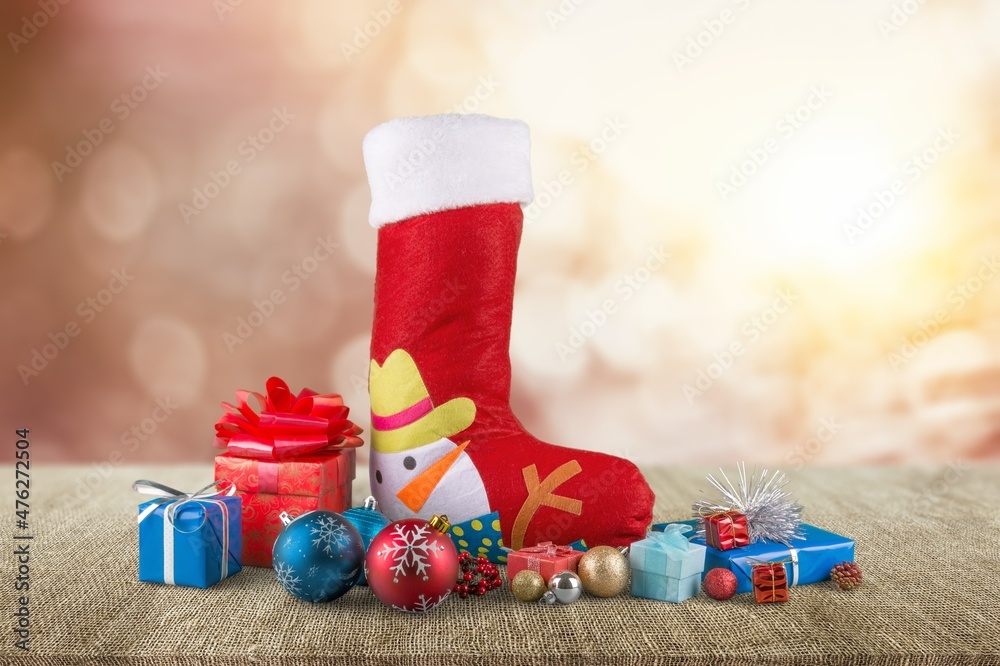 Stuffed Santa Claus boot with sweets, gift box.Cute background with bokeh golden lights