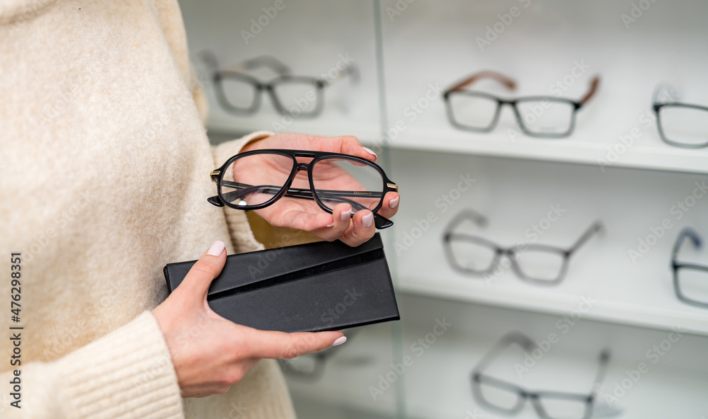 Stylish eyeglasses holding in hands. Eyewear modern glasses with stylish lens.