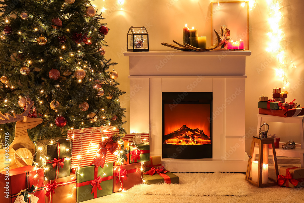 Fireplace with beautiful Christmas tree and gifts in living room at night