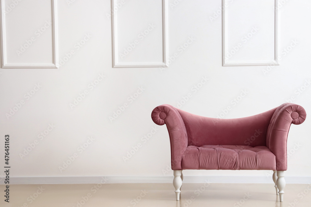 Pink armchair near light wall