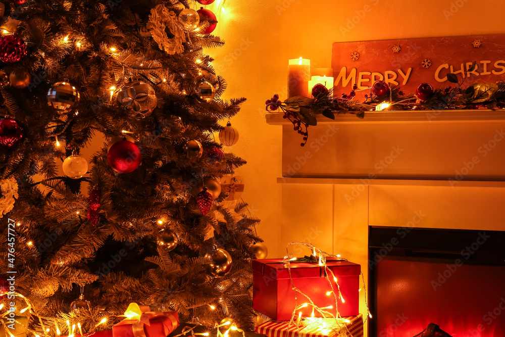 Fireplace with beautiful Christmas tree in living room at night