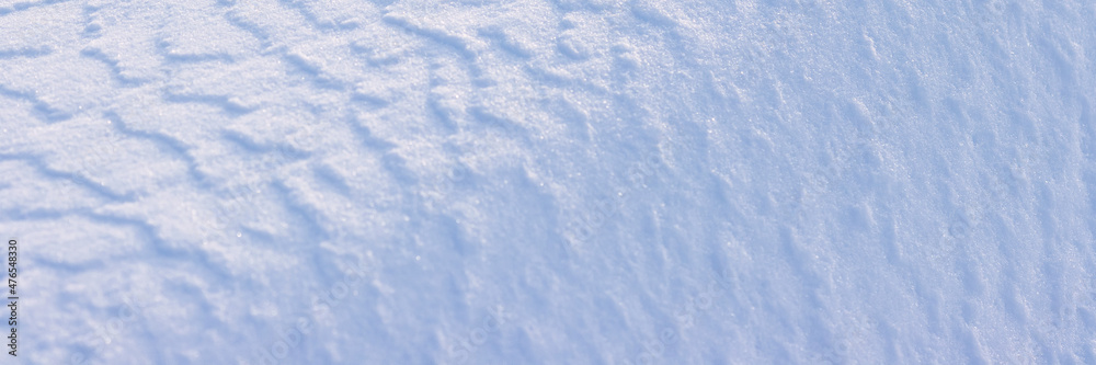 美丽的冬季背景，雪地。自然的雪纹理。风在雪上雕刻图案