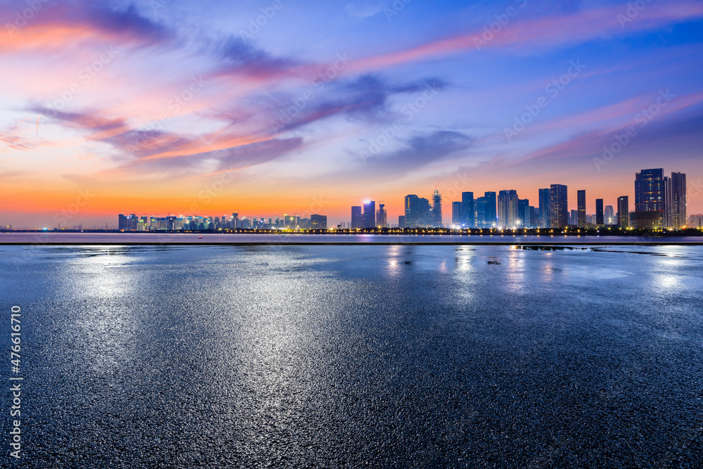 全景天际线和空荡荡的现代商业建筑。阳光下的沥青道路和城市景观