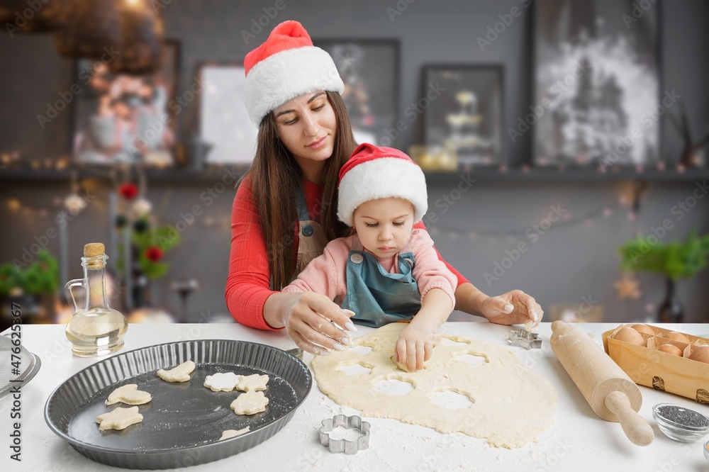 友好的年轻母亲带着小女儿在现代厨房做饭