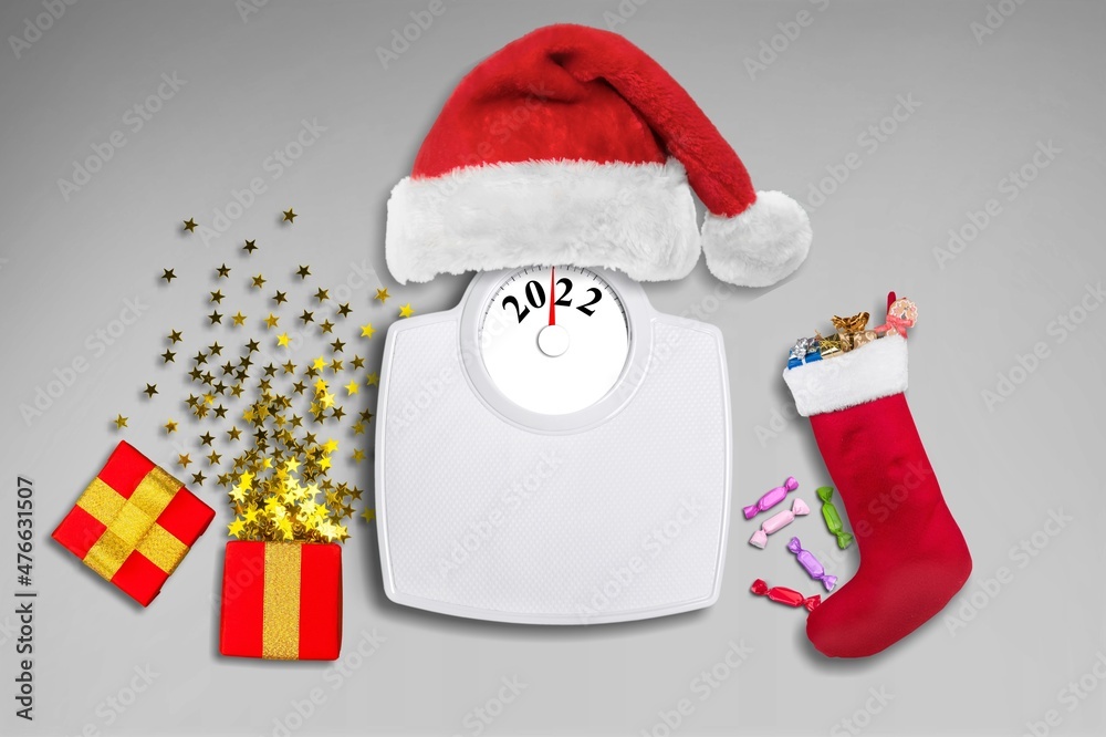 Scales with Santa hat and Christmas decoration on background. New year concept. Top view.