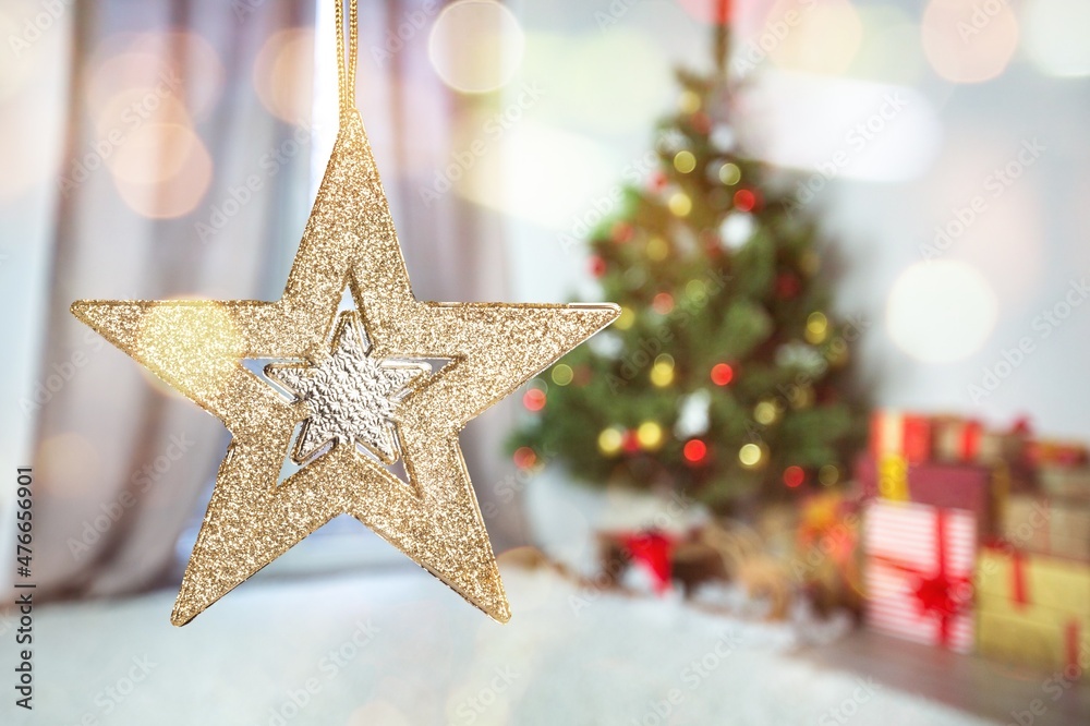 Christmas star on background of christmas lights in evening room.