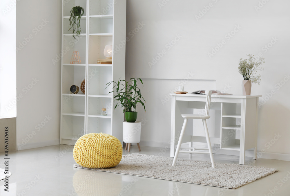 Interior of light room with modern workplace and yellow pouf