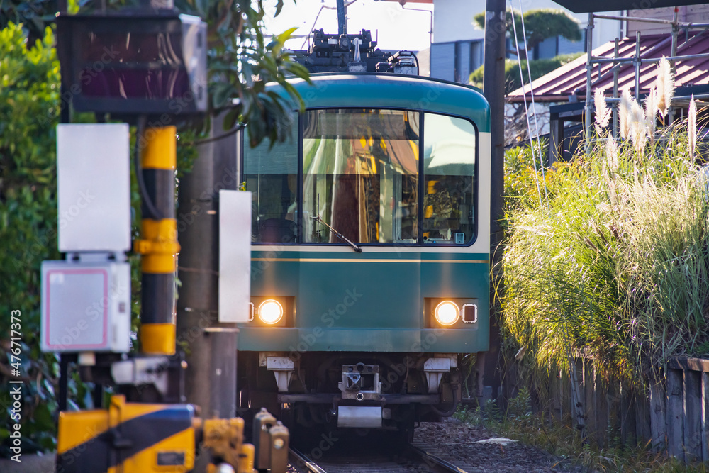 住宅の裏の狭い隙間を走るローカル線