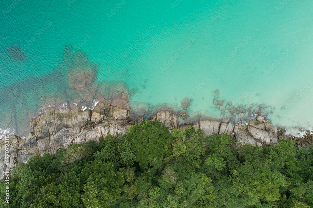 鸟瞰图自上而下，海浪拍打着海岸，阳光明媚，美丽的绿松石海面