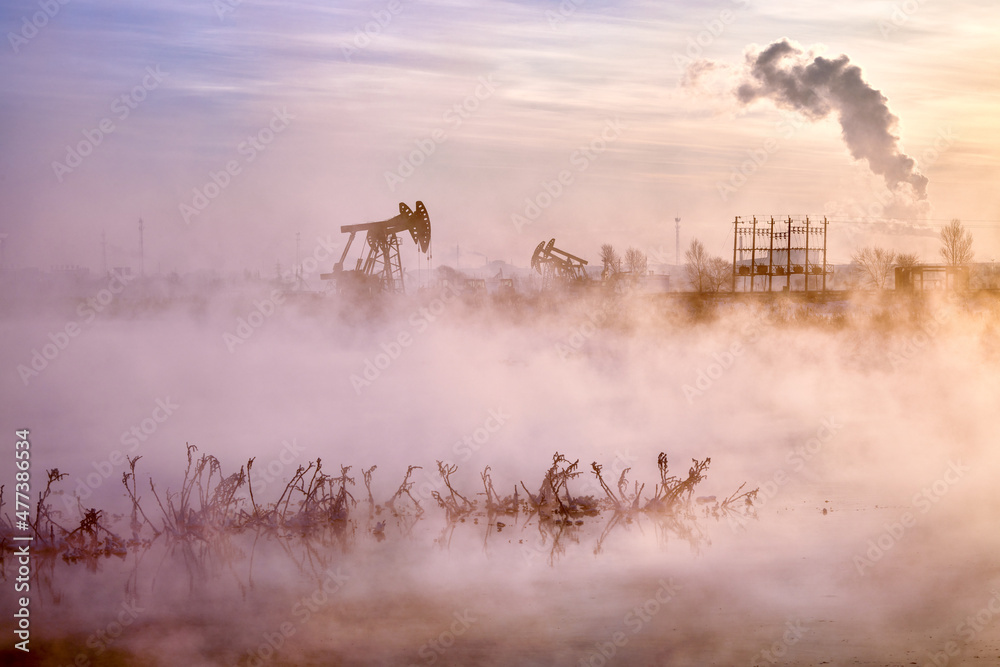 The pumping units in lakeside sunrise, Daqing oil fields Heilongjiang province, China.