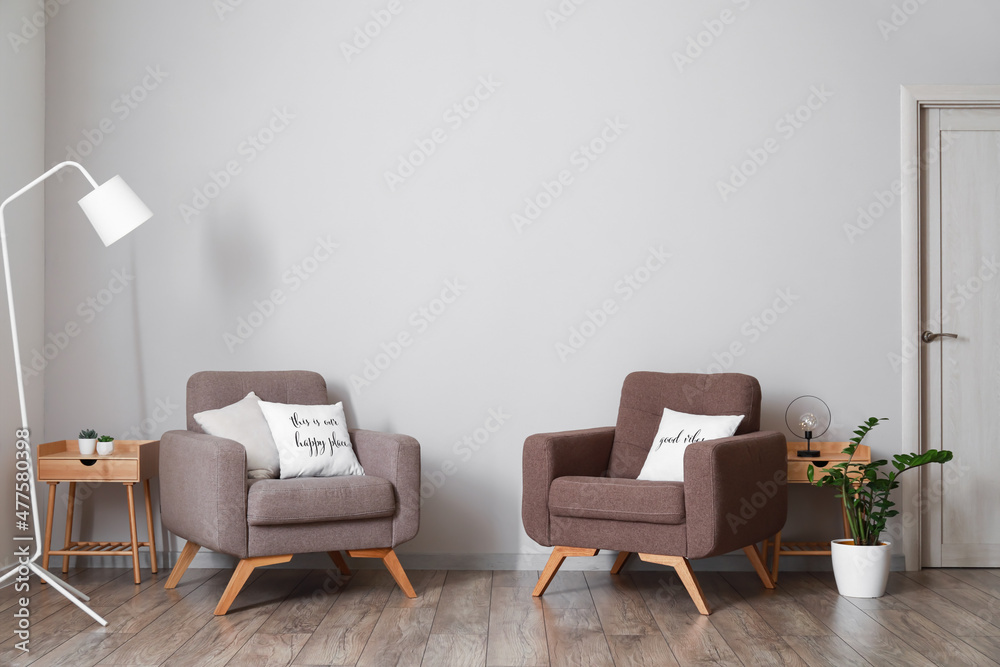 Interior of modern living room with comfortable armchairs and standing lamp