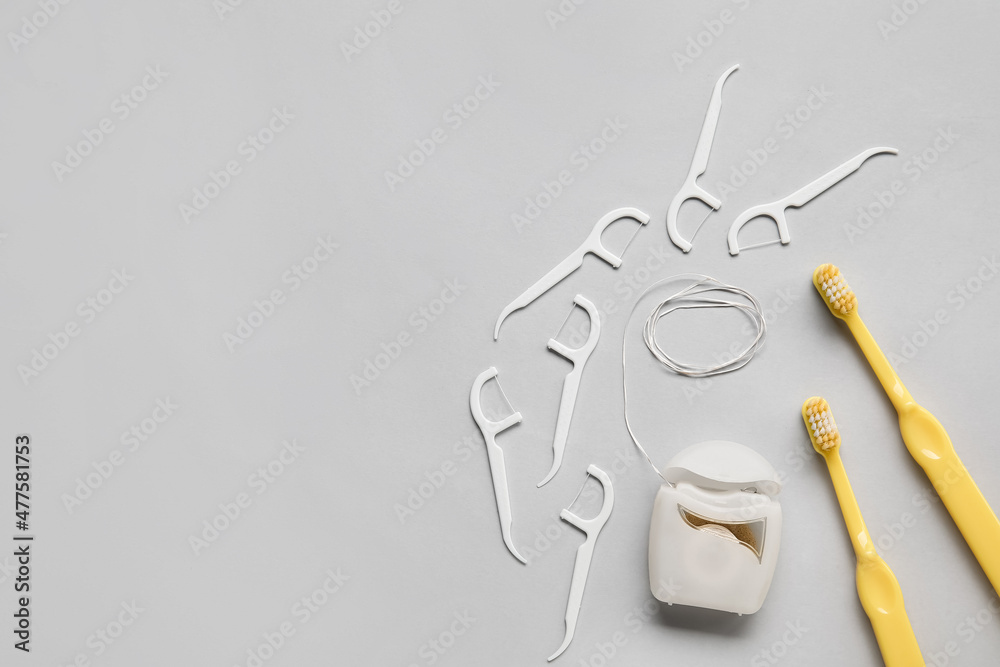 Dental floss, toothpicks and brushes on light background