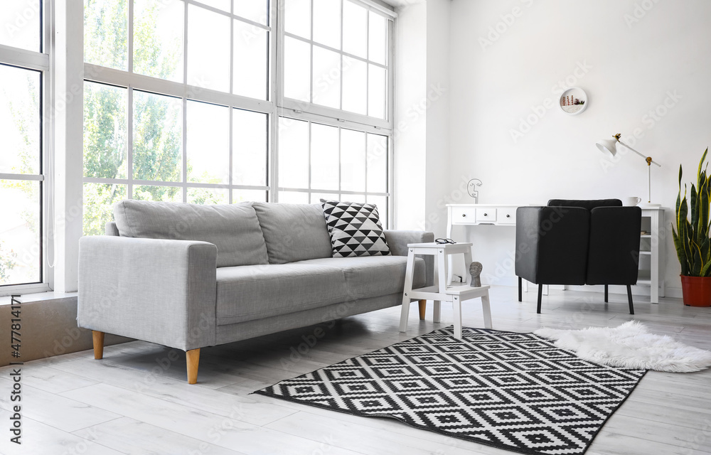 Interior of light living room with white step stool and sofa