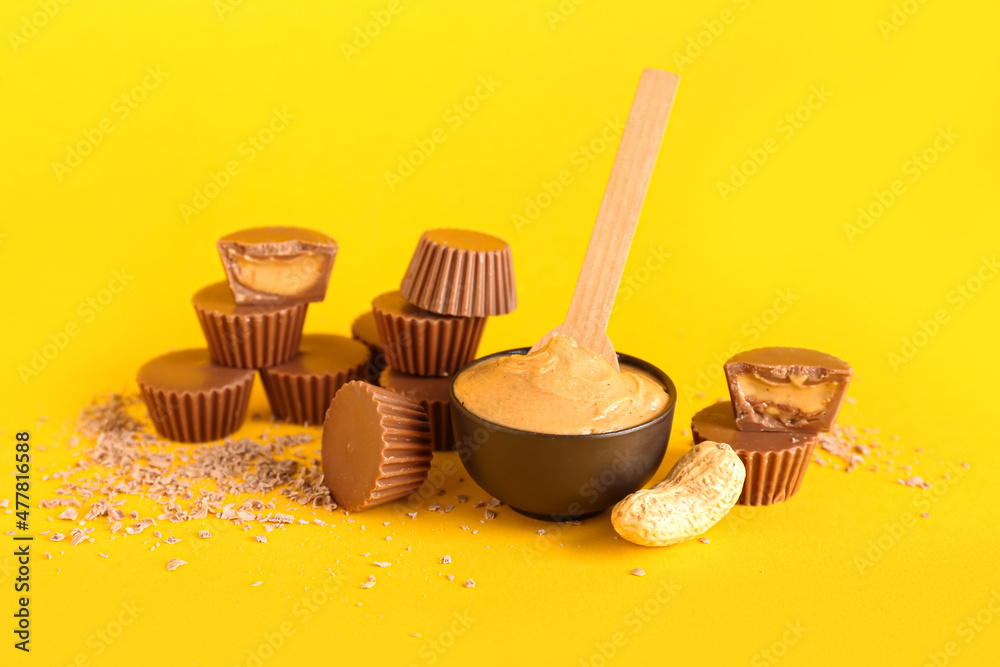 Tasty peanut butter cups on color background