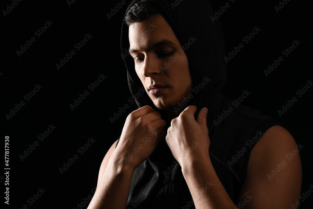 Portrait of sporty young man on black background