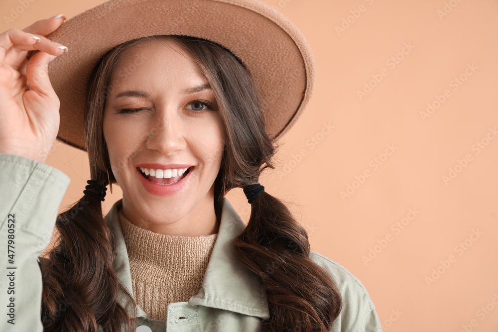 Portrait of pretty woman winking on color background