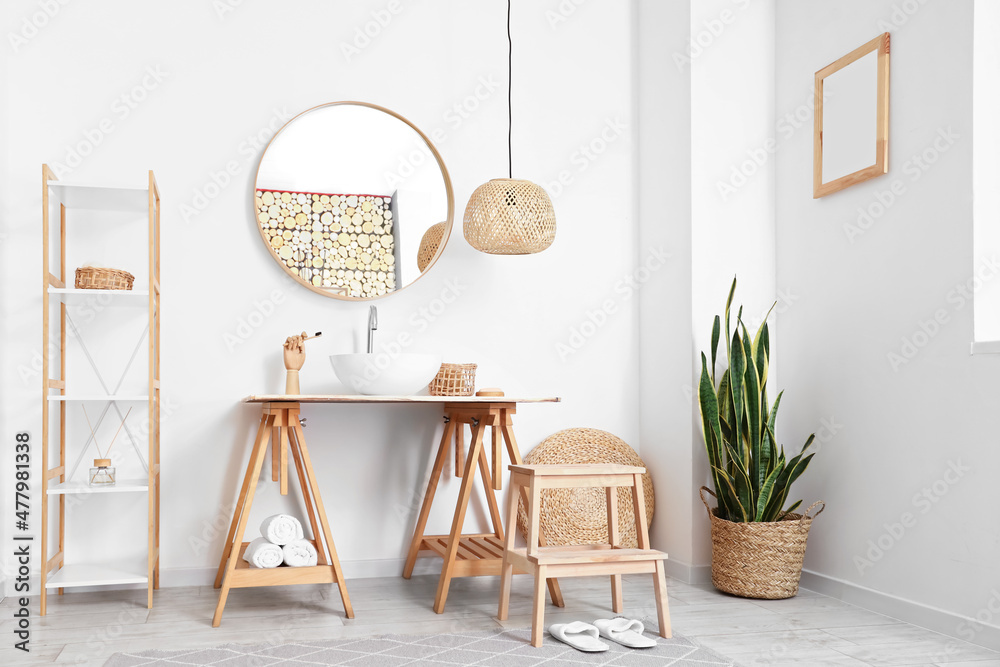 Interior of light bathroom with sink, mirror and step stool